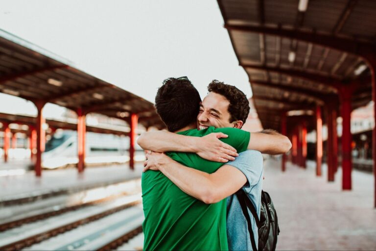 two people hugging on a platform